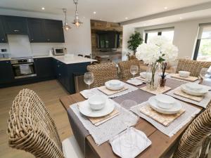 comedor y cocina con mesa y sillas en Driftwood Haven, en St Ives