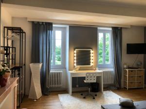 a living room with a desk and a mirror at Chez Celine et Philippe chambre Marie dans propriété de charme avec piscine in Le Fossat