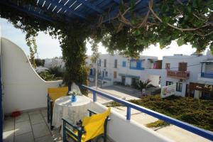 a table and chairs on the balcony of a building at Vitzileos Studios in Agios Prokopios