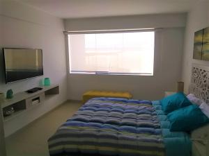 a bedroom with a bed and a large window at Apartamento Playa Señoritas in Punta Hermosa