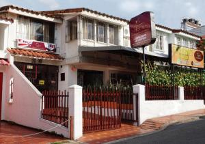 un edificio con una valla y una señal delante de él en Hotel Don Juan Colonial en Floridablanca