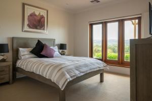 a bedroom with a bed and a large window at WayWood Wines Your Vineyard Getaway in McLaren Flat