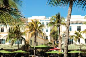 a hotel with palm trees and umbrellas in front of it at Hotel Ocean in Miami Beach