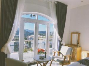 a living room with a large window with a view at Greenview Dalat in Da Lat