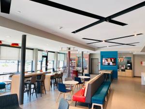 a restaurant with tables and chairs and a ceiling at Avid hotels - Beaumont, an IHG Hotel in Beaumont