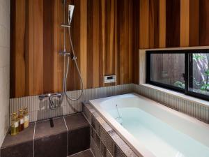 a bath tub in a bathroom with a window at Natsume an Machiya House in Kyoto +28 photos