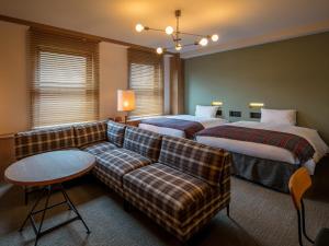 a living room with two beds and a couch at Twin-Line Hotel Karuizawa Japan in Karuizawa