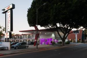a car parked in front of a building with purple doors at Astro Pasadena Hotel in Pasadena