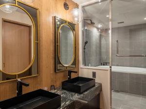軽井沢町にあるTWIN-LINE HOTEL KARUIZAWA JAPANのバスルーム(黒い洗面台、鏡付)