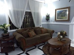 The Winford Boutique Hotel Achimota في آكرا: غرفة معيشة مع أريكة وطاولة