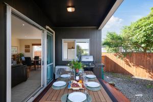 eine Terrasse mit einem Tisch und Tellern darauf in der Unterkunft Tranquil Tauhara - Taupo Central Holiday Home in Taupo