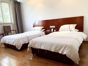 a bedroom with two beds and a wooden headboard at Tianxinglou Hotel in Nanjing