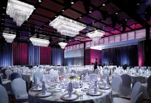 a large banquet hall with white tables and white chairs at StarWorld Hotel in Macau