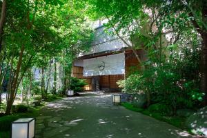 a walkway in front of a building with trees at Hakuunsou in Yugawara