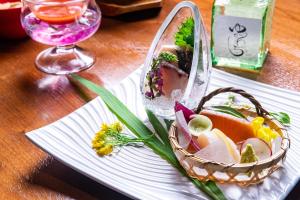 un plato con una cesta de comida en una mesa en Hakuunsou, en Yugawara