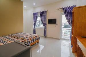 1 dormitorio con 1 cama, TV y ventana en Cẩm Tú Cầu 27 Lê Hồng Phong en Da Lat
