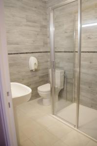 La salle de bains est pourvue de toilettes et d'un lavabo. dans l'établissement Hôtel De Paris, à Barneville-Carteret