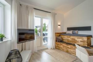 ein Wohnzimmer mit einem Sofa, einem TV und einem Fenster in der Unterkunft Heimelig im Allgäu in Lindenberg im Allgäu