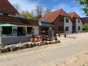 ein Gebäude mit Bänken vor einem Gebäude in der Unterkunft Gasthof Ostwind - ferienwohnungen & meer in Steffenshagen