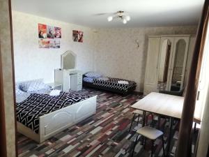 a room with two beds and a table and chairs at Заветы Ильича in Vityazevo