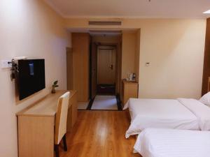 a hotel room with two beds and a television at 7Days Inn Yancheng Jianhu Xiu Fu South Road in Yancheng