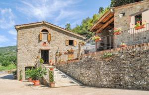 een stenen gebouw met bloemen op een stenen muur bij Il Moraiolo - Idromassaggio & Sauna con vista! in Loro Ciuffenna