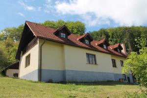 a house with a red roof on a field at Chata pod lesom Nová Baňa in Nová Baňa
