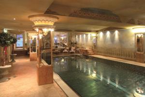 a large swimming pool in a large room with a building at Verwöhnhotel Kristall in Pertisau