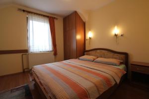 Un dormitorio con una cama con dos almohadas y una ventana. en Apartmani Višnja, en Zlatibor