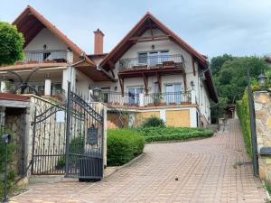 a house with a gate and a brick driveway at HolidaySport Haus in Balatongyörök