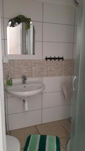 bagno con lavandino e specchio di Penzion-Na Navsi a Horní Planá