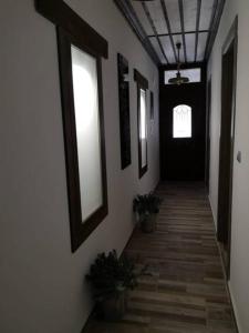 a hallway with white walls and a black door at Anna Studios in Mariaí