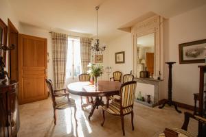 una sala da pranzo con tavolo e sedie di Maison de village -8 pers- Piscine chauffée & cuisine d'été en Gascogne a Mézin