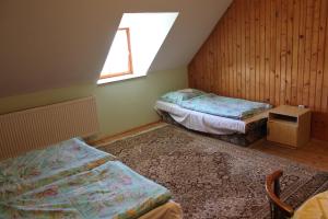 a attic room with two beds and a window at Chata pod lesom Nová Baňa in Nová Baňa