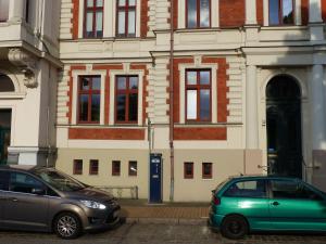 dos coches estacionados frente a un edificio en Vis-a-vis-Berliner-Tor, en Schwerin