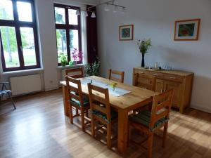 een eetkamer met een houten tafel en stoelen bij Vis-a-vis-Berliner-Tor in Schwerin