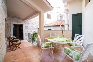 a room with a table and chairs on a patio at Villa Providenca in Kaštela