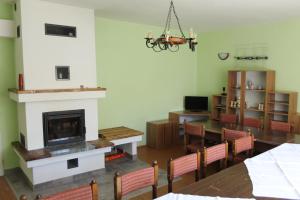 a living room with a fireplace and a table and chairs at Chata pod lesom Nová Baňa in Nová Baňa