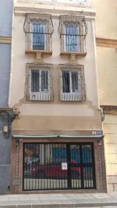a building with three windows and a gate at AYZ Frailes - Auto check-in property in Málaga