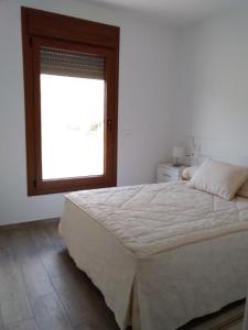 a bedroom with a large bed and a window at Paraíso de Torrox Costa in Torrox Costa