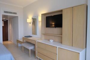 a hotel room with a large bed and a television at Sunrise Beach Hotel in Protaras