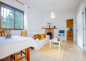 een woonkamer met een witte bank en een open haard bij VILLA SENSACIONES in Tarifa