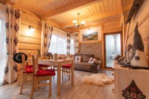 a dining room and living room with a table and chairs at Domki Pod Jemiołą in Zakopane