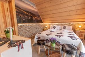 a bedroom with a bed and two tables with flowers at Domki Pod Jemiołą in Zakopane