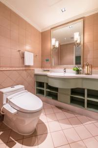 a bathroom with a toilet and a sink and a mirror at Green Court Residence City Center, Shanghai in Shanghai