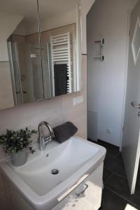 bagno con lavandino bianco e specchio di Hafenperle am Suhrenpohl a Heiligenhafen