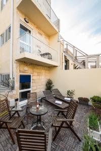 um pátio com cadeiras, uma mesa e uma varanda em Valletta Ajkla Mansion em Valletta