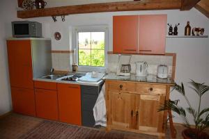 a kitchen with orange cabinets and a sink at Ferienwohnung Leich in Diedorf