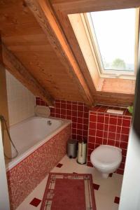 a bathroom with a bath tub and a toilet at Ferienwohnung Leich in Diedorf