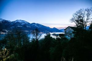 a house on the shore of a lake with mountains at Casa ALMA in Brione sopra Minusio